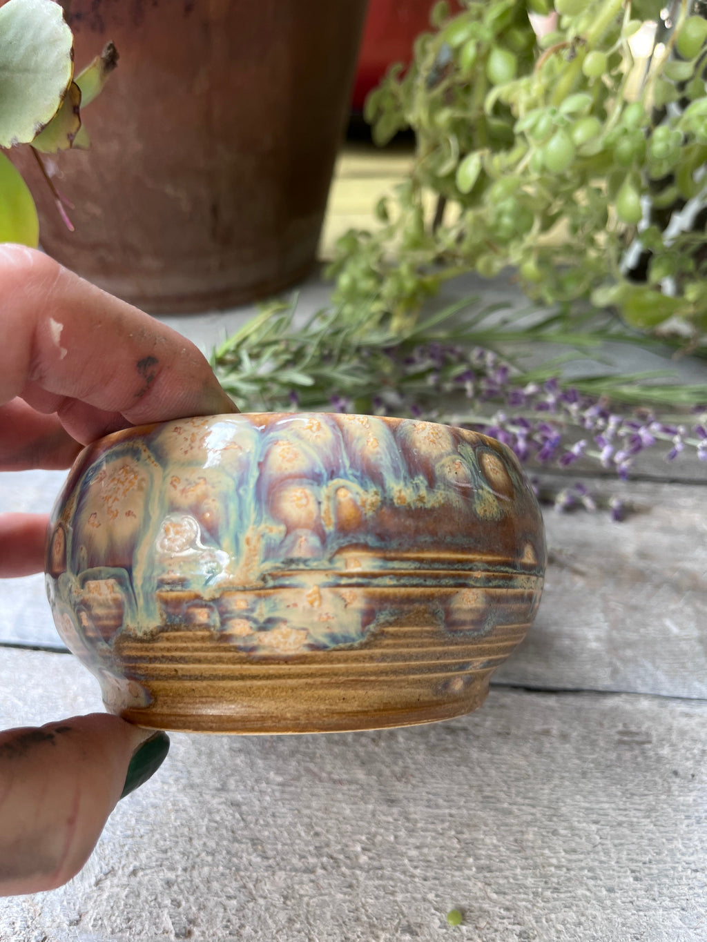 Handmade ceramic bowl with drip glaze in amber, blue, and violet