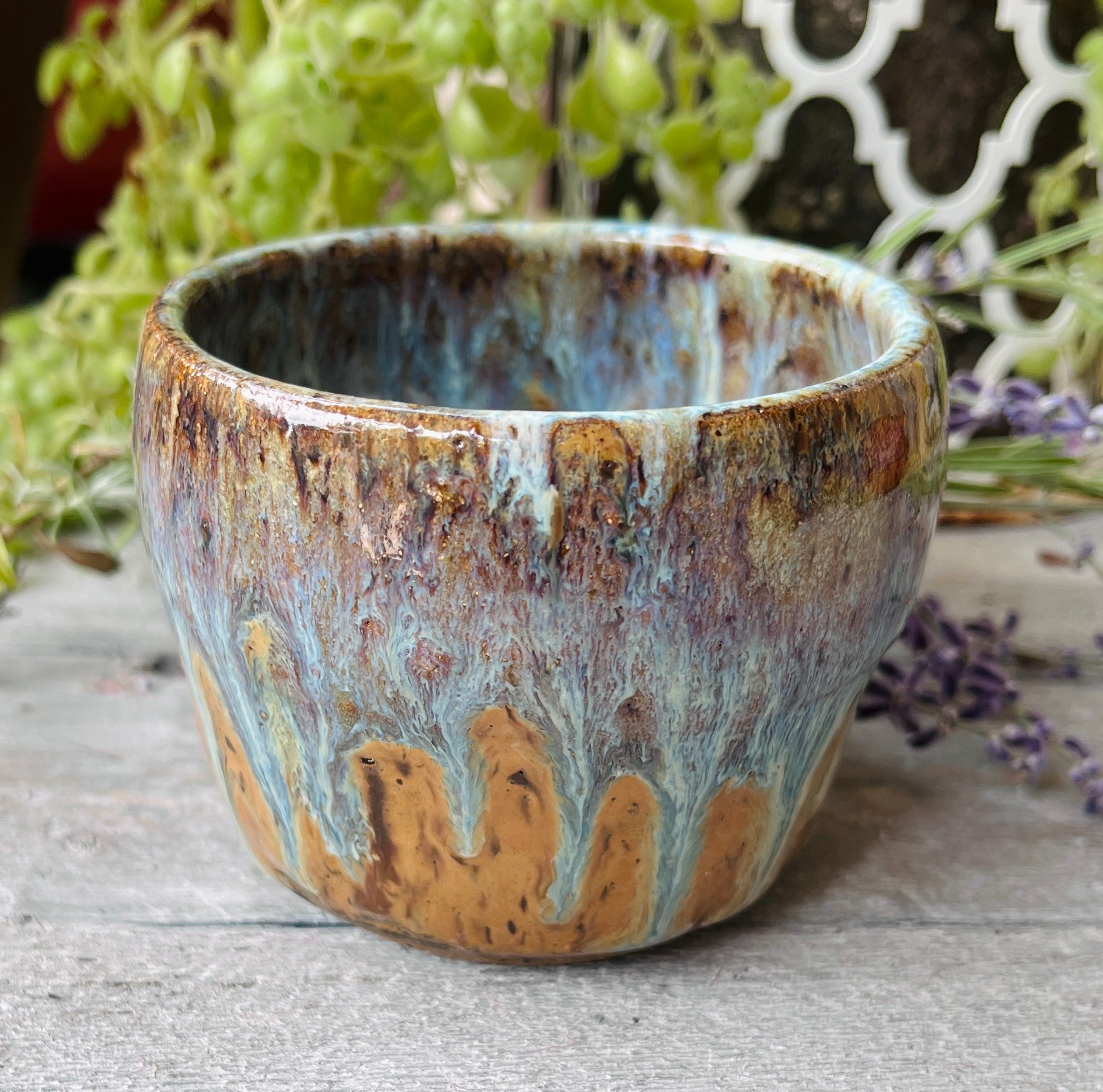 Handmade ceramic bowl with layered amber, blue, and violet drip glaze