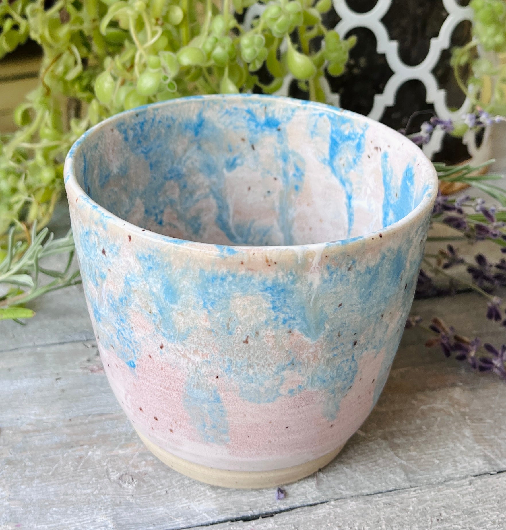Handmade ceramic bowl with soft blue and blush pink swirl glaze on speckled clay