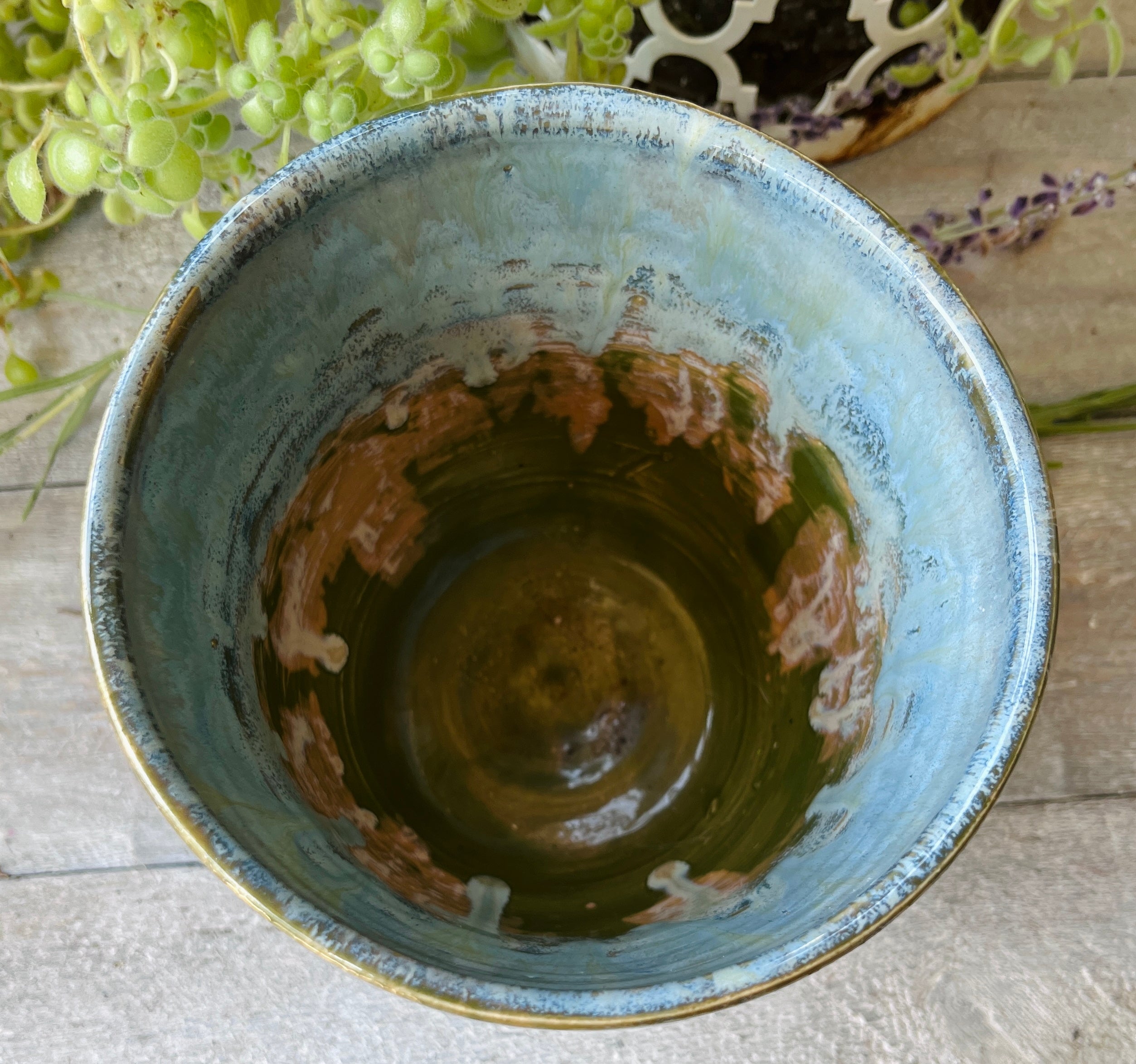 Interior view of handmade ceramic bowl showing swirling moss green and blue glaze